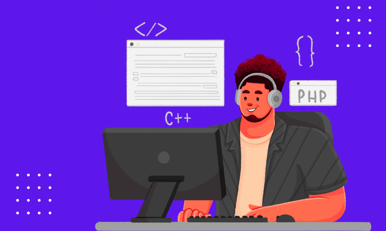 A man seated at a desk, working on a computer and a laptop, focused on his tasks.